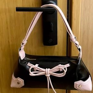 babydoll faux shoulder bag w adjustable strap. Pink bow on front of bag. 💕